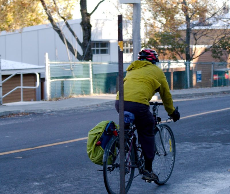 a man riding a bike down a street next to a traffic light